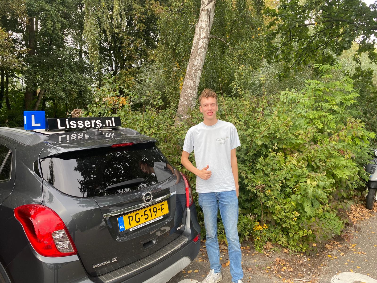 Wout Honsbeek bij de lesauto van Rijschool Lissers na het behalen van zijn rijbewijs